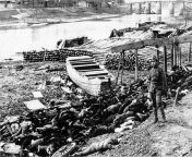 An IJA soldier stands next to a pile of Chinese civilians who were killed during the Nanjing massacre near the Qinhuai River. During the massacre, the River became reddened with blood as it was filled with tens of thousands of bodies, December, 1937, (800 from imgsru river