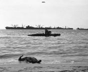 American sailors of the US Navy in two boats and the body of a dead soldier on the coast of southern France, Invasion of Normandy. 1944 from xxx on the coast