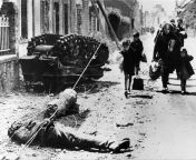 Some of the inhabitants of Pont-L&#39;abbe in the Finistere region passing before the wreck of a German Sd.Kfz.2 Kleines Kettenkraftrad HK and the body of a German soldier, before the American army had entered the city in June 1944. from fallen makina and the city of ruins goblin
