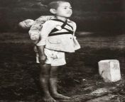A young Japanese boy stands to attention with his dead brother at a cremation pyre, in 1945. This picture is meant to show the impacts of the firebombing of civilian areas of Japan. from xxx hindi bf haseemajak pagal waldaree wex of japan
