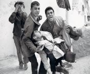Tom Hurndall, British photography student, being carried unconscious by two local youth after he was shot in the head in the Gaza Strip by a (IDF) sniper, Taysir Hayb while attempting to rescue a child who had been pinned down by gunfire on 11 April 2003. from 2003 නංගීට වඩාගෙන හුකනවා