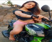 Jolly Bhatia navel in navy blue top and pink shorts on green Yamaha bike from jolly bhatia