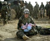 U.S. Navy Hospital Corpsman HM1 Richard Barnett, assigned to the 1st Marine Division, holds an Iraqi child in central Iraq, on March 29, 2003. Confused front line crossfire ripped apart an Iraqi family after local soldiers appeared to force civilians towa from xrares iraqi force