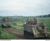 Vietnam War. Phuoc Tuy Province. July 1967. A US Army M113 ACAV (Armored Combat Attack Vehicle) followed by an M557 Armored Command Vehicle (ACV), both variants of the M113 family, carrying soldiers of of the US 11th Armored Cavalry Regiment (11ACR) durin from vehicle hide