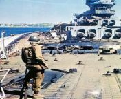 An American soldier on the deck of the destroyed French battleship Strasbourg in Toulon. On the side of the battleship lies the light cruiser La Gallissoniere. from battleship