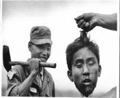 The severed head of North Korean Communist guerrilla held up by a member of the South Korean National Police, Cholla Poktuk, South Korea, November 17, 1952 from south korean anal pain
